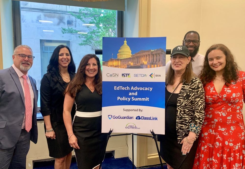 Six people standing next to a sign titled EdTech Advocacy and Policy Summit